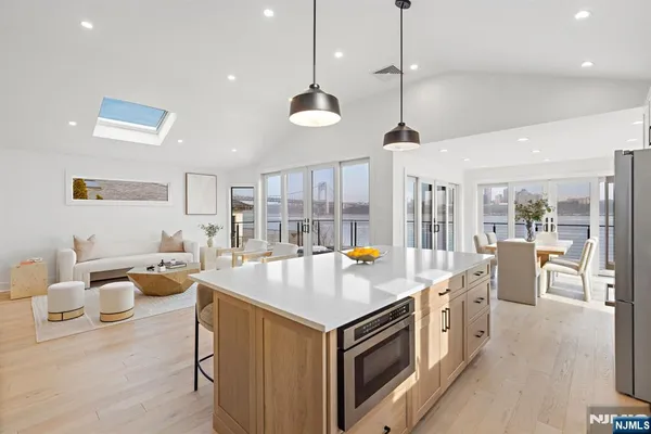 a open kitchen with stainless steel appliances granite countertop a lot of cabinets a sink dishwasher and a stove with wooden floor