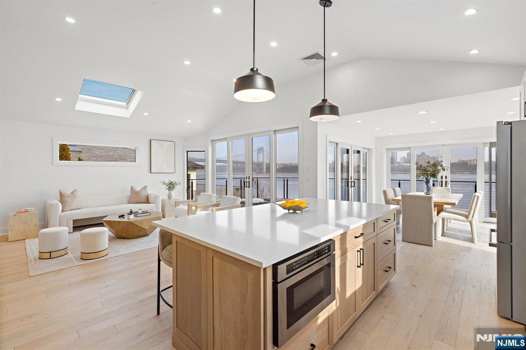 27 Shore Road Edgewater, NJ 07020 - Photo 8 of 48 a open kitchen with stainless steel appliances granite countertop a lot of cabinets a sink dishwasher and a stove with wooden floor