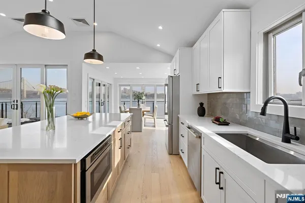 a kitchen with stainless steel appliances granite countertop a sink a stove and a refrigerator