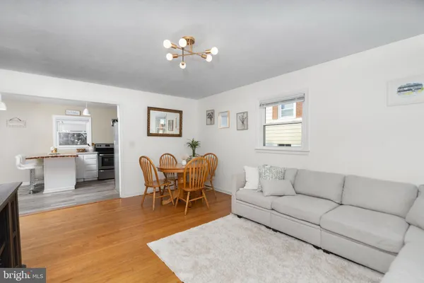 a living room with furniture a dining table and kitchen view