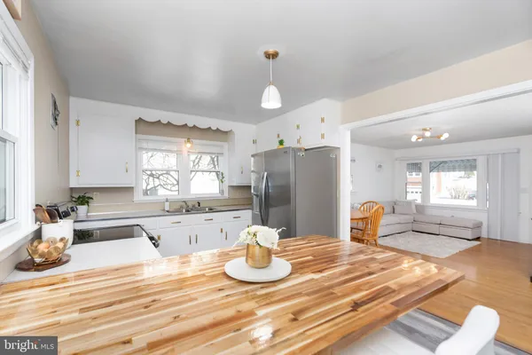 a kitchen with stainless steel appliances granite countertop a sink dishwasher a stove a refrigerator with a dining table and chairs
