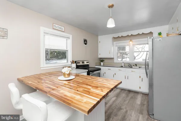 a kitchen with granite countertop a stove a sink a dining table and chairs