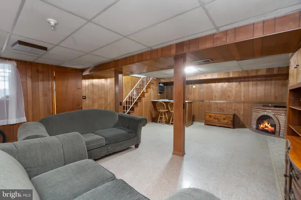 a living room with furniture and a gym machine with wooden floors