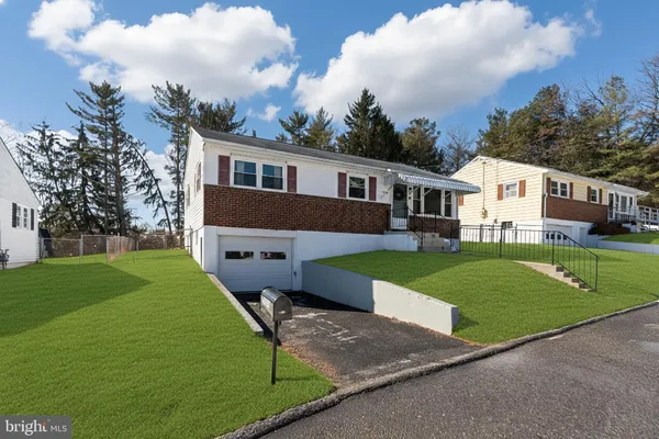 a front view of a house with a garden and yard