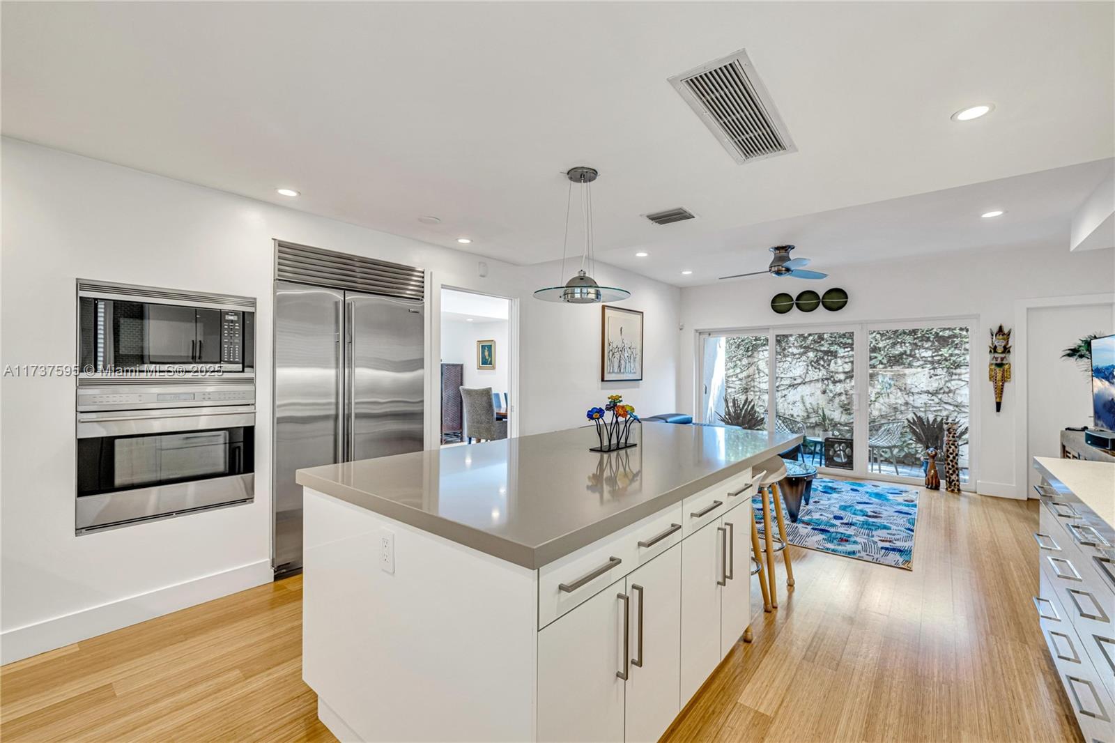 3701 Solana Road Miami, FL 33133 - Photo 15 of 38 a large kitchen with stainless steel appliances kitchen island a large counter top and a wooden floor