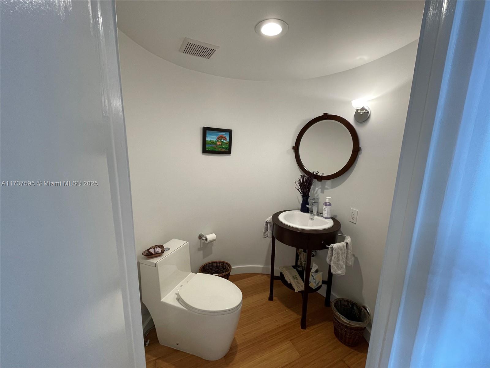 3701 Solana Road Miami, FL 33133 - Photo 18 of 38 a bathroom with a toilet a sink and a mirror