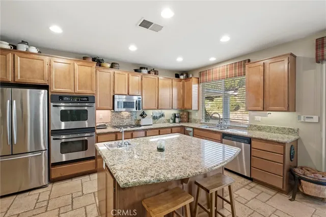 a kitchen with granite countertop a sink a counter space and cabinets