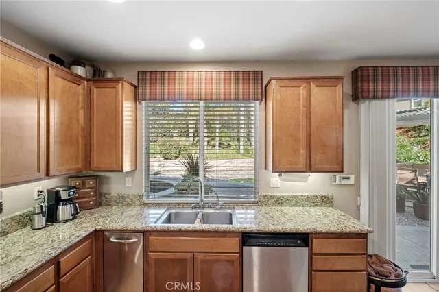 a view of a dining room and livingroom with furniture wooden floor a rug a painting and a chandelier