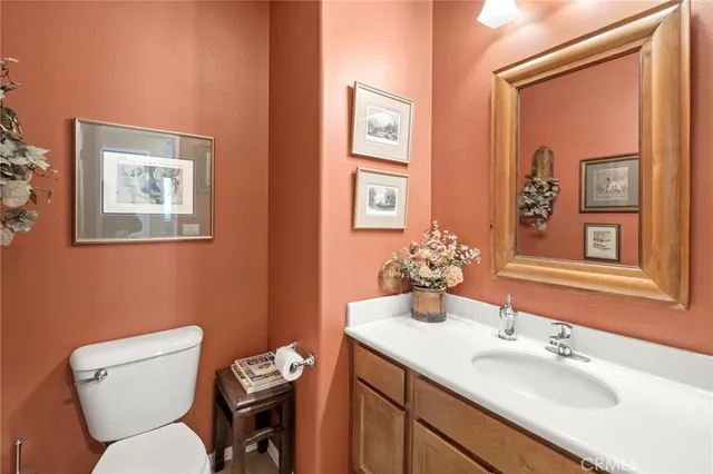 a view of staircase with lots of frames on wall and wooden floor