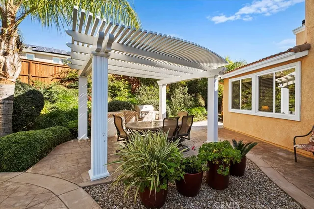 a view of a patio with table and chairs potted plants with wooden floor and fence