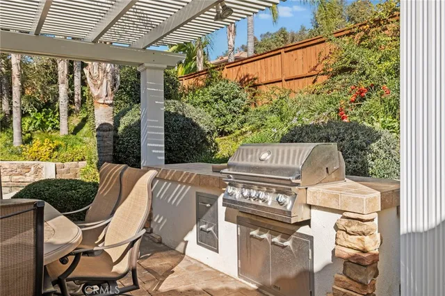 a view of a chair and tables in patio with a barbeque grill