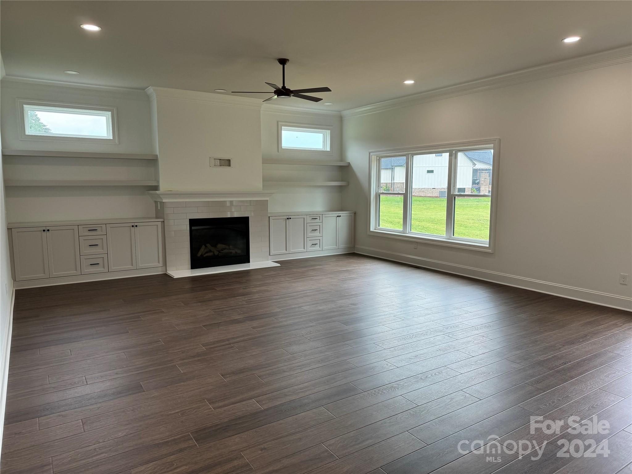 4305 Holly Circle Northeast Conover, NC 28613 - Photo 15 of 36 an empty room with wooden floor a fireplace and windows