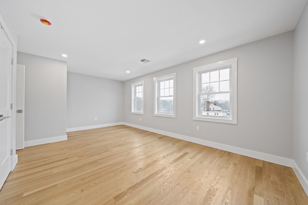 77 Neponset Street, Unit 77 Canton, MA 02021 - Photo 16 of 28 a view of an empty room with wooden floor and a window