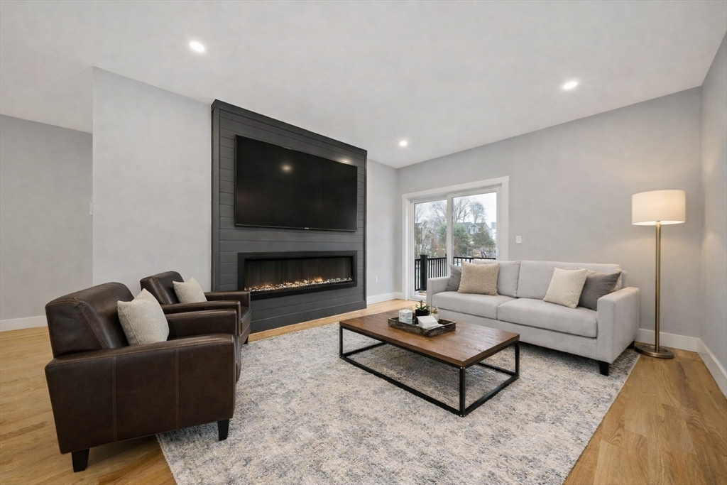 77 Neponset Street, Unit 77 Canton, MA 02021 - Photo 2 of 25 a living room with furniture a flat screen tv and a fireplace