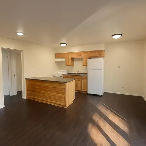 a kitchen with granite countertop white cabinets and white appliances