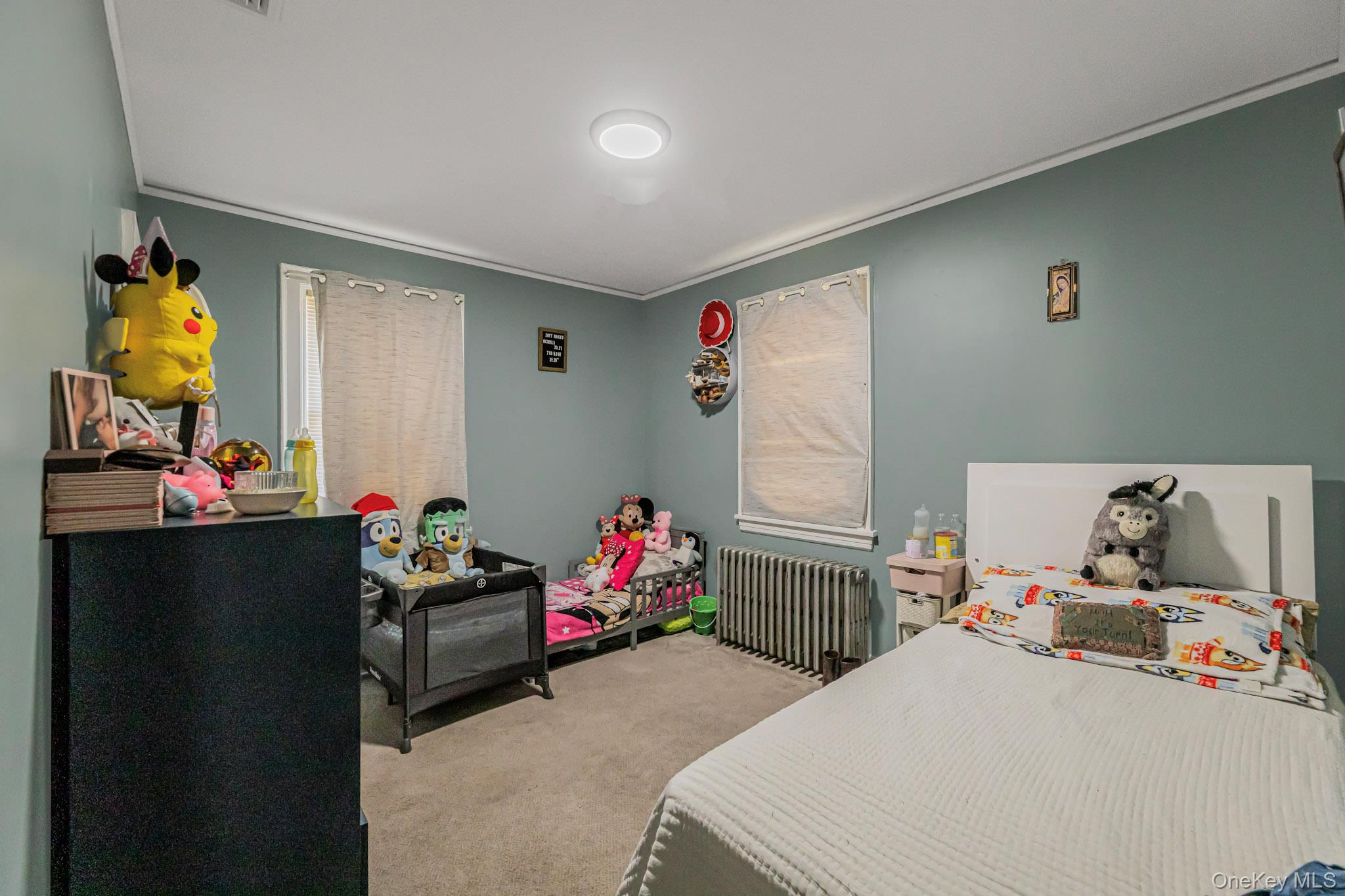 168 Stephenson Boulevard New Rochelle, NY 10801 - Photo 17 of 21 Bedroom with radiator heating unit, light carpet, and crown molding