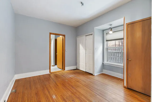 an empty room with wooden floor and a window