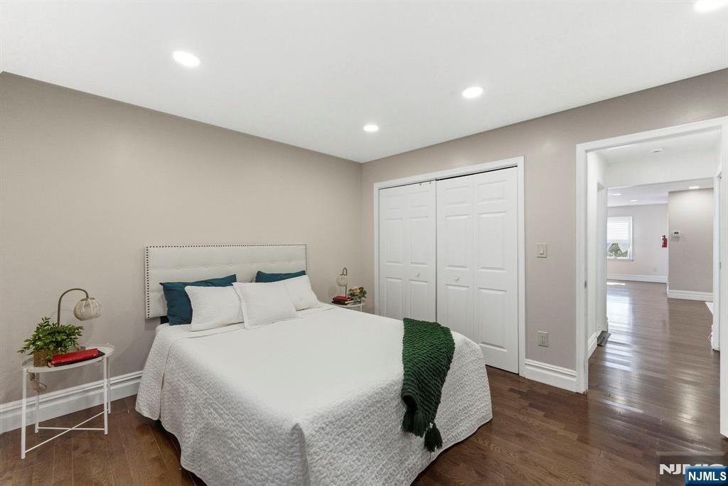 144 70th Street, Unit 1E Guttenberg, NJ 07093 - Photo 11 of 20 a bedroom with a bed and wooden floor