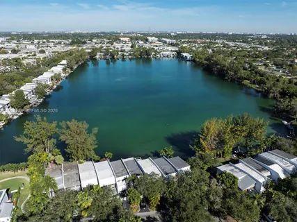 an aerial view of residential houses with outdoor space and lake view