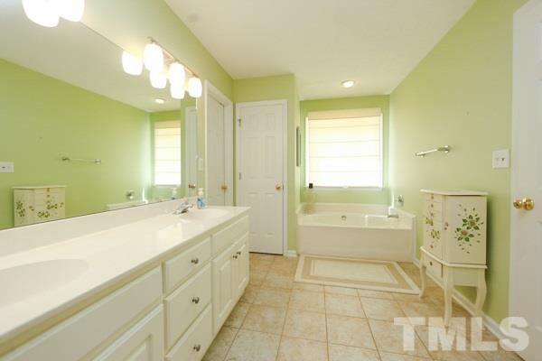 122 Forest Lane Garner, NC 27529 - Photo 9 of 18 a spacious bathroom with a mirror a double vanity sink and a mirror