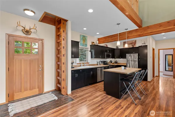 a kitchen with stainless steel appliances kitchen island granite countertop a stove refrigerator and cabinets