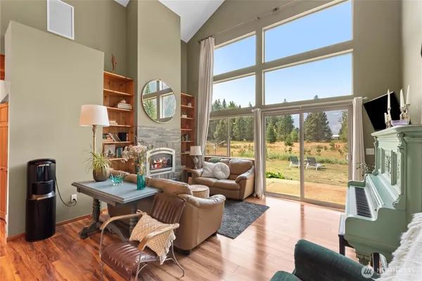 a living room with furniture a fireplace and a floor to ceiling window
