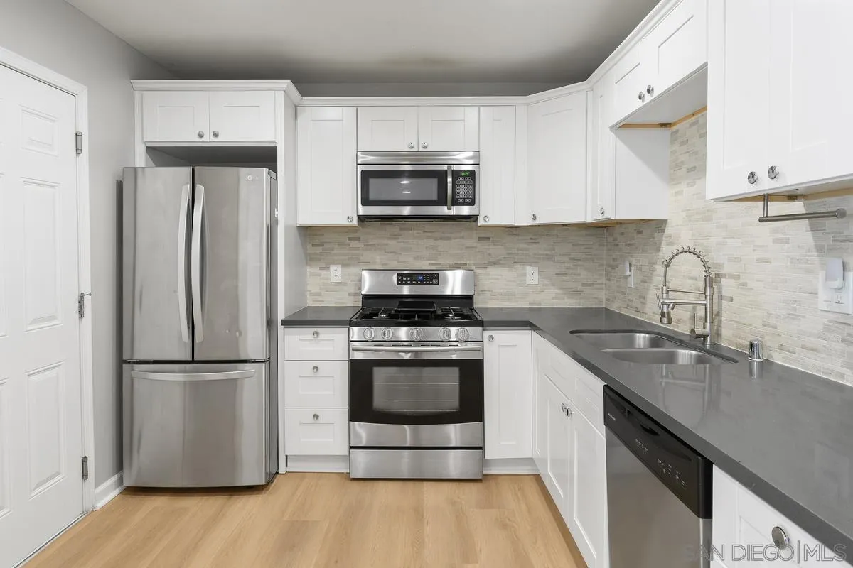 180 5th Avenue Chula Vista, CA 91910 - Photo 7 of 18 a kitchen with granite countertop a refrigerator stove and sink