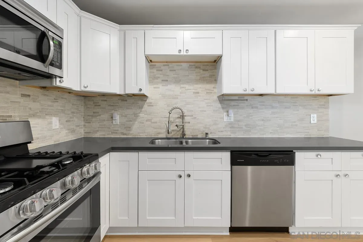 180 5th Avenue Chula Vista, CA 91910 - Photo 8 of 18 a kitchen with granite countertop white cabinets and stainless steel appliances