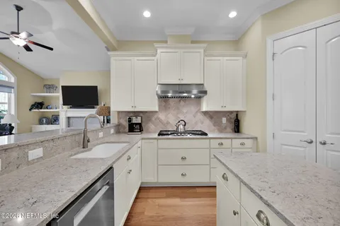 a kitchen with granite countertop white cabinets and white appliances