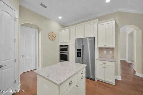 a kitchen with white cabinets and stainless steel appliances