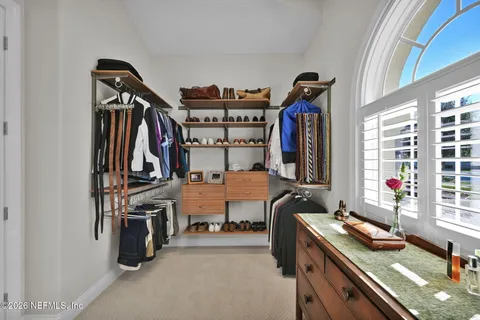 a view of walk in closet with clothes and shoes