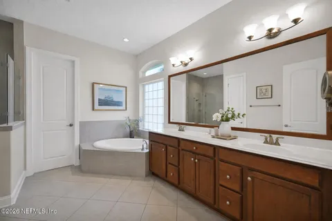a bathroom with a sink double vanity tub and a mirror