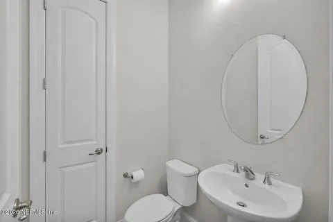 a bathroom with a toilet a sink and a mirror