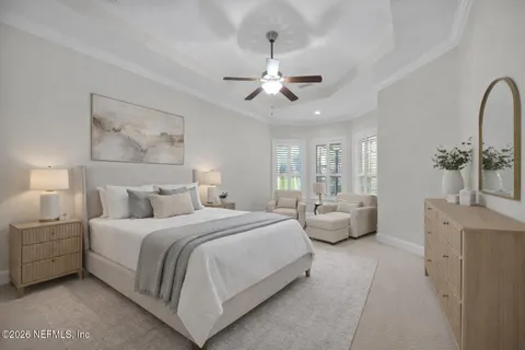 a bedroom with a large bed and ceiling fan