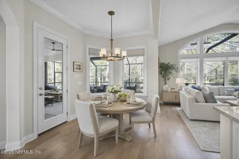 a living room with furniture a large window and a chandelier