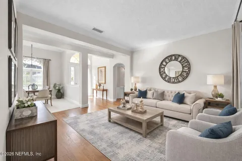 a living room with furniture a clock and a large mirror