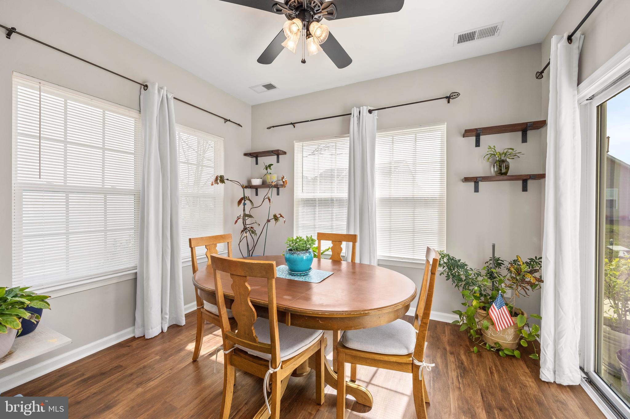 191 Bobbys Branch Road Millsboro, DE 19966 - Photo 12 of 40 a dining room with furniture potted plants and wooden floor