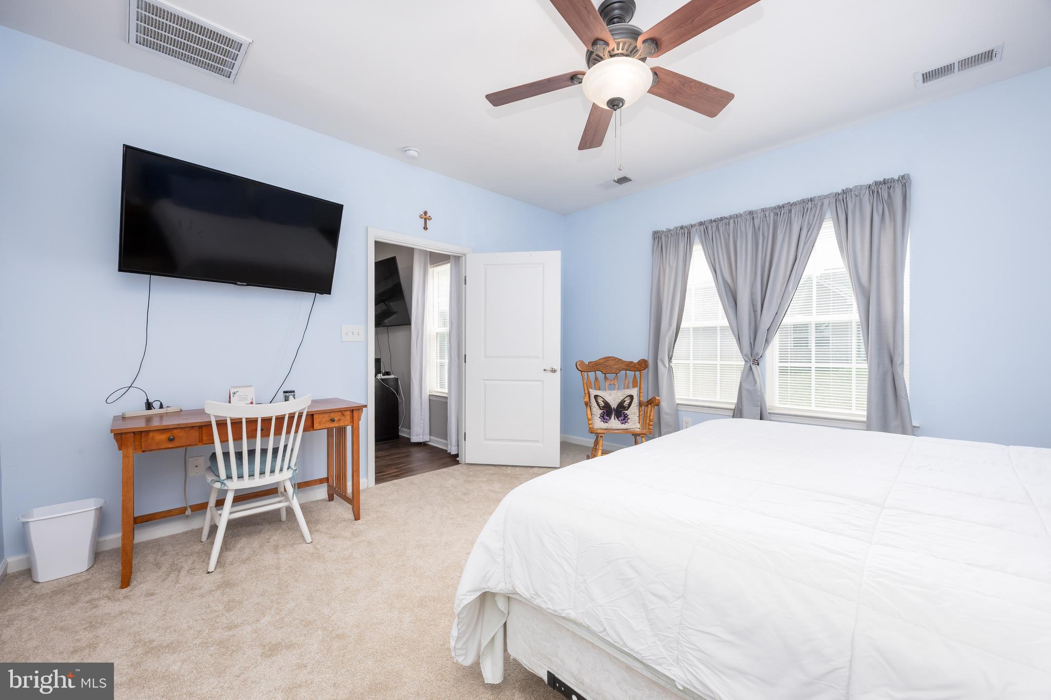 191 Bobbys Branch Road Millsboro, DE 19966 - Photo 20 of 40 a bedroom with a bed a flat screen tv and a chandelier