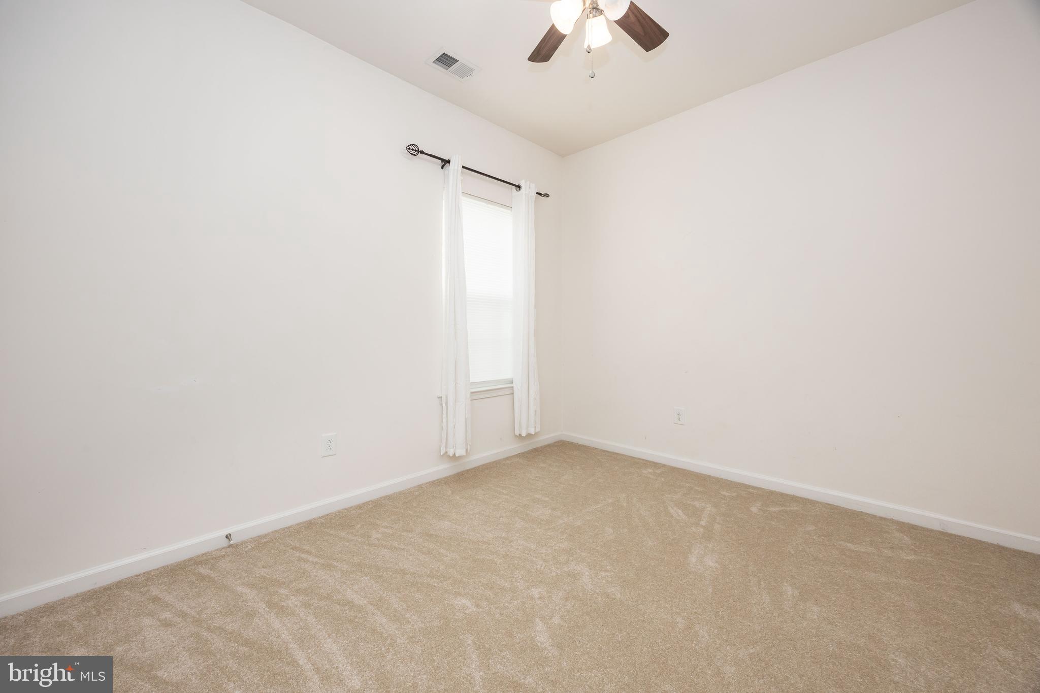 191 Bobbys Branch Road Millsboro, DE 19966 - Photo 30 of 40 an empty room with a chandelier fan and windows