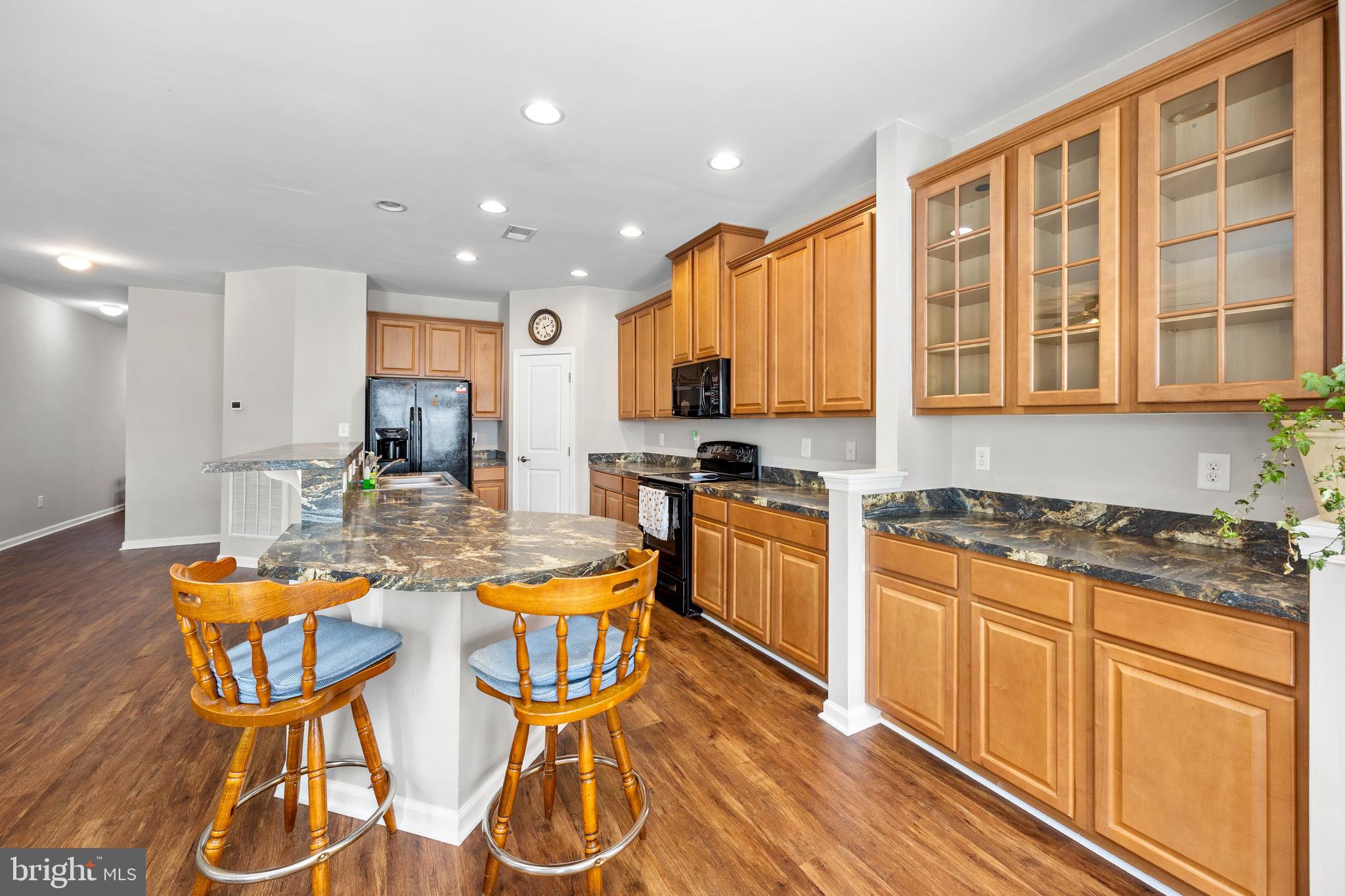 191 Bobbys Branch Road Millsboro, DE 19966 - Photo 8 of 40 a kitchen with stainless steel appliances granite countertop a stove top oven a dining table and chairs with wooden floor