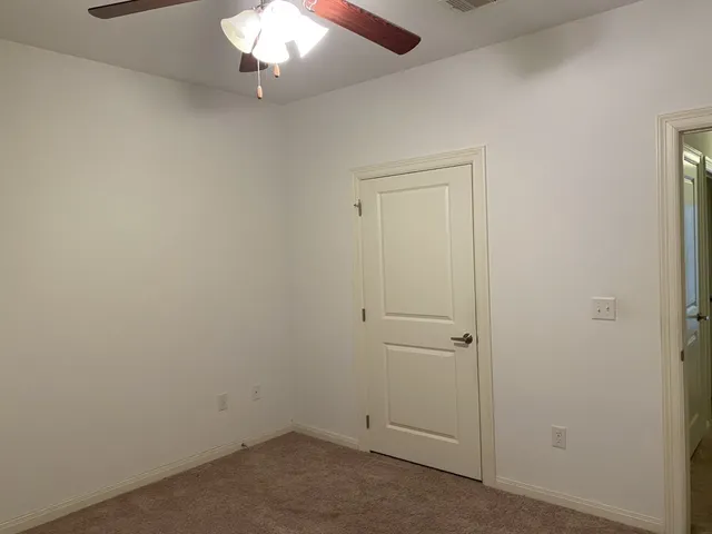 an empty room with a chandelier fan