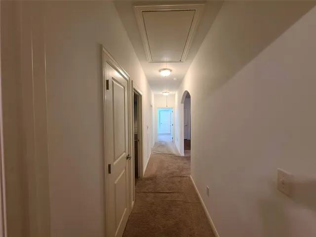 a view of hallway with a bathroom