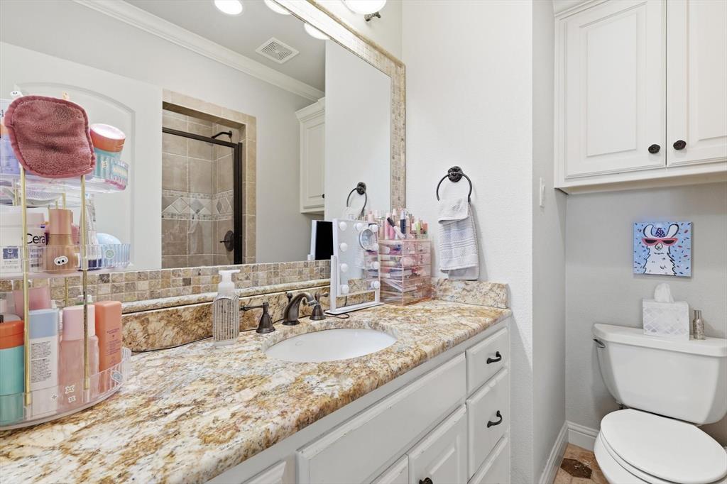 476 Hidden Valley Lane Coppell, TX 75019 - Photo 22 of 40 a bathroom with a granite countertop sink a toilet and a mirror