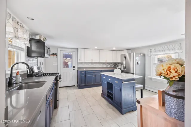 a kitchen with stainless steel appliances granite countertop a stove top oven a sink dishwasher and a refrigerator