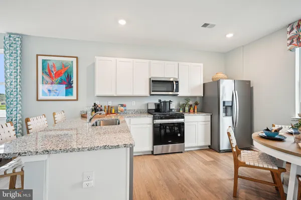 a kitchen with stainless steel appliances granite countertop a refrigerator stove microwave and sink