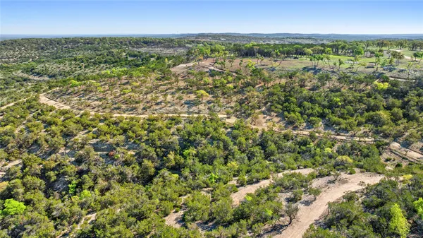 an aerial view of residential houses with outdoor space and trees