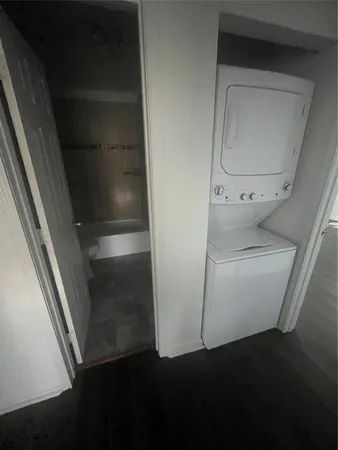 a utility room with wooden floor washer and dryer