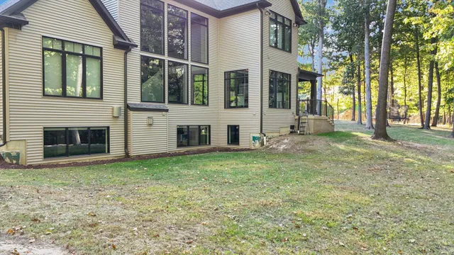 a front view of a house with a garden and trees