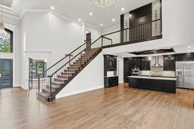 a room with a chandelier fan and a window