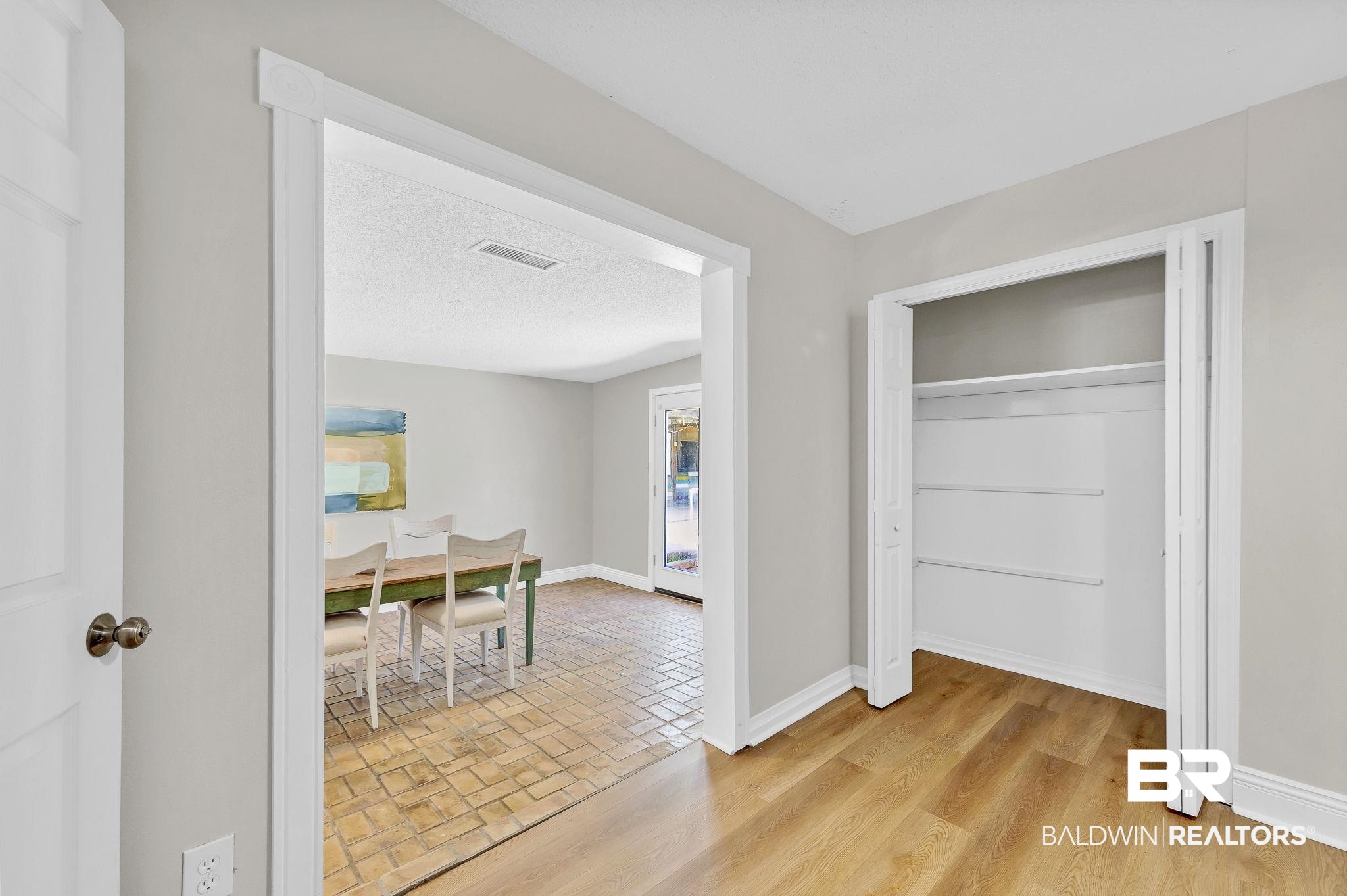 11964 Stroh Road Daphne, AL 36527 - Photo 23 of 58 Interior space featuring brick floor, visible vents, baseboards, and a textured ceiling